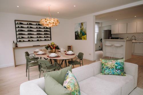 a living room with a white couch and a table with chairs at Vakantiewoning De Curiositeit in Geraardsbergen