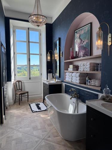 a bathroom with a tub and two sinks and a window at Chateau Forest in Arette