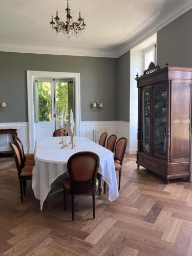 a dining room with a table with chairs and a chandelier at Chateau Forest in Arette