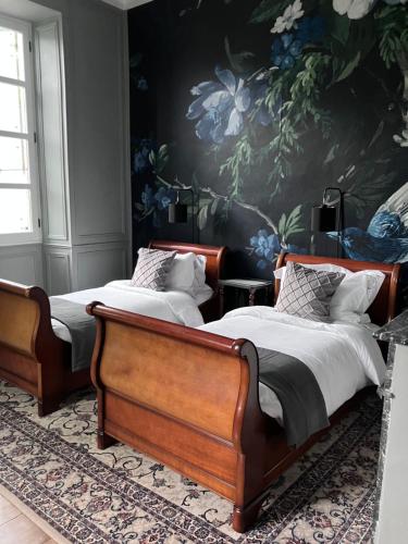 two beds in a bedroom with a floral wall at Chateau Forest in Arette