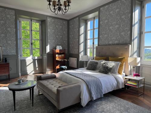 a bedroom with a bed and a couch and windows at Chateau Forest in Arette