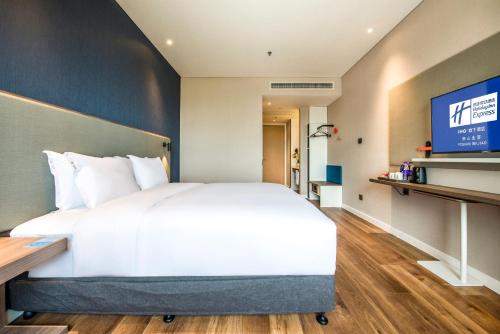 a bedroom with a large bed and a television at Holiday Inn Express Foshan Beijiao by IHG in Shunde