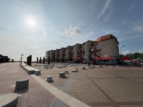 a row of buildings with benches in a courtyard at Appartament ,,Marti strand Makkum'' in Makkum