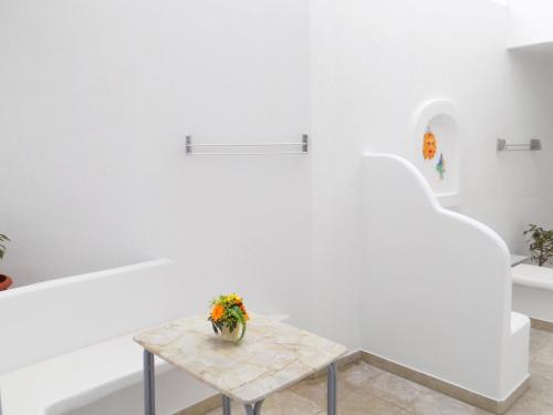 a white room with a table with flowers on it at Anemos Studios in Adamas