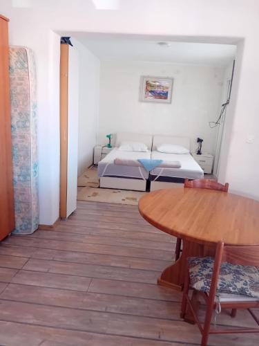 a room with a bed and a table and a bed at Apartments Butkovic in Hvar