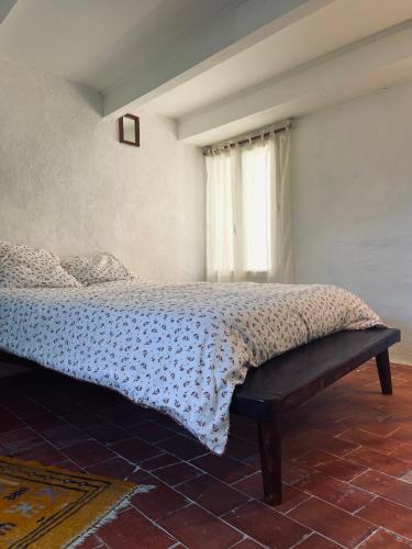 une chambre avec un lit et une fenêtre dans l'établissement La Biscornue, à Lauris