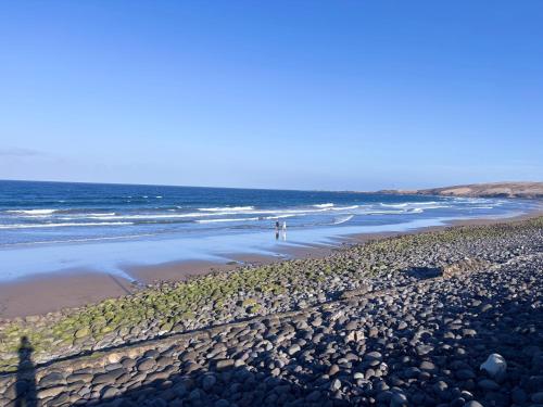 two people walking on a beach with the ocean at Villa Vargas Paraiso in Carrizal