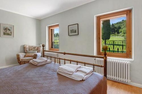 a bedroom with a bed and a chair and a window at Eco Farm La Cavallina in Affi