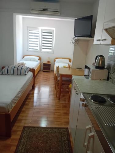 a small room with two beds and a kitchen at Apartments Butkovic in Hvar