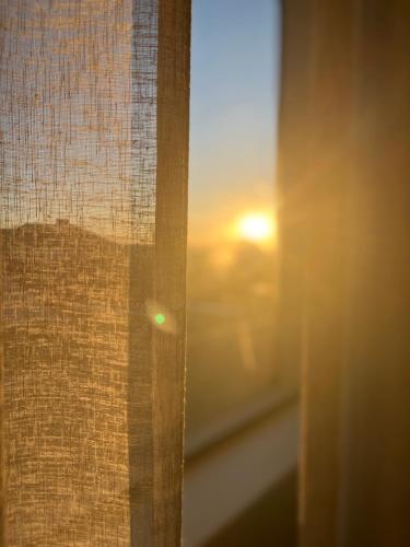 a close up of a window with the sunset at Stylish OceanBreeze 50 Central Mossel Bay in Mossel Bay
