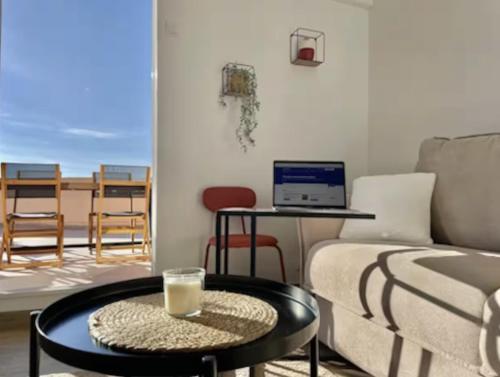 a living room with a couch and a table with a laptop at Rooftop Privé Plein Soleil Mer Plage Port in Bandol