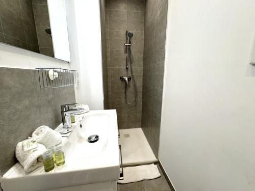 une salle de bain avec un lavabo et une douche dans l'établissement ApartHotel Riviera - MAISON DU GRAND SUD - Confortable petit 3 pièces - Promenade des Anglais, à Nice