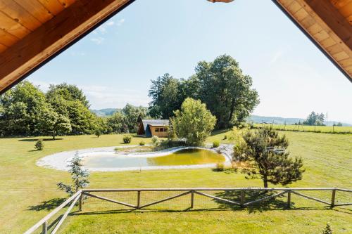 an aerial view of a farm with a pond in a field at Log Garden Estate in Dobrova