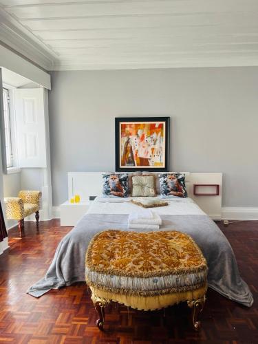 a bedroom with a large bed with a ottoman at Casa Amore in Montemor-o-Velho