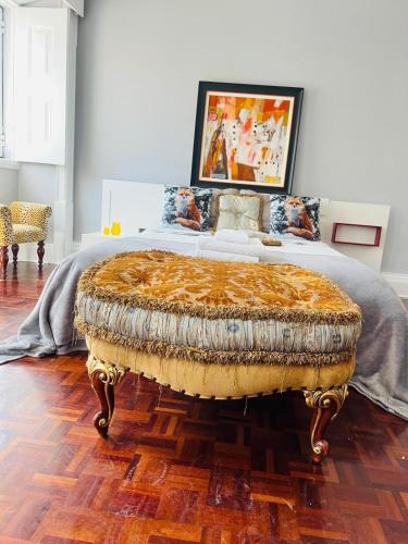 a bedroom with a king sized bed with a large ottoman at Casa Amore in Montemor-o-Velho
