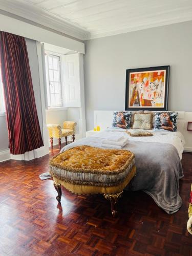 a bedroom with a king sized bed with a large ottoman at Casa Amore in Montemor-o-Velho