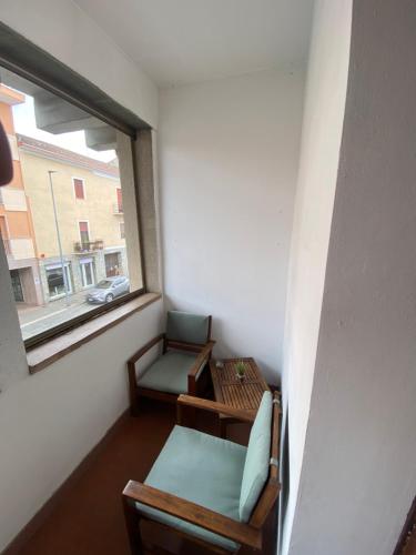 a room with two chairs and a window at Misani Apartments in Novara