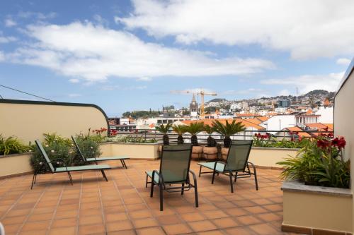 a patio with chairs and tables on a roof at Anadia Penthouse Duplex by Rent-a-key in Funchal