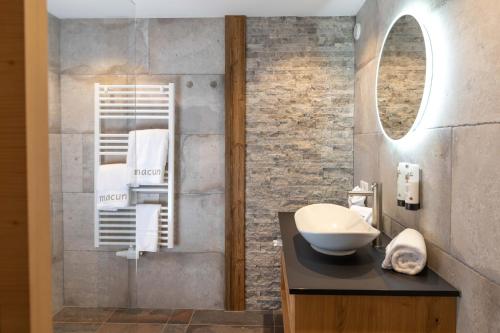 a bathroom with a sink and a mirror at Hotel Macun, Vent im Ötztal in Vent