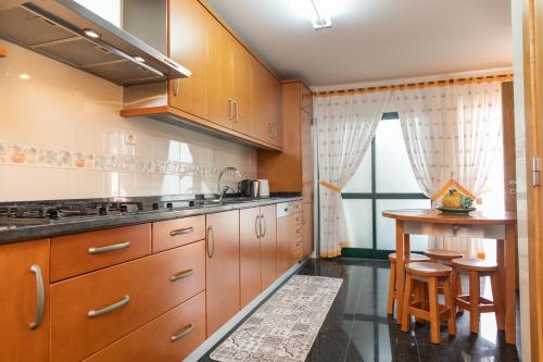 a kitchen with wooden cabinets and a small table at Anadia Penthouse Duplex by Rent-a-key in Funchal
