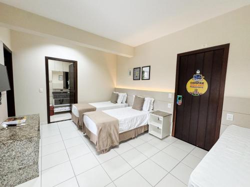 a hotel room with two beds and a bathroom at Pousada Doluar in Penha