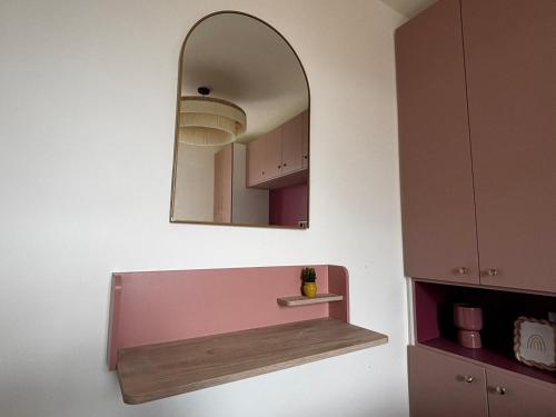 un miroir suspendu sur un mur avec une étagère dans l'établissement Bel appartement cosy, superbe vue mer ! pour 6 personnes, à Le Touquet-Paris-Plage