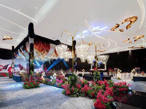 a banquet hall with flowers and chandeliers at Radisson Golf & Convention Center Batam in Batam Center