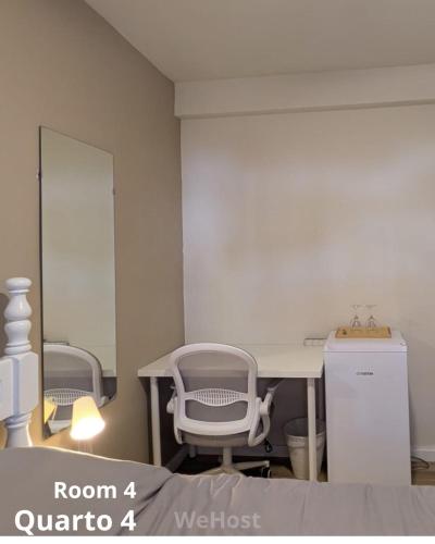 a room with a table and chairs and a mirror at We host in Costa da Caparica