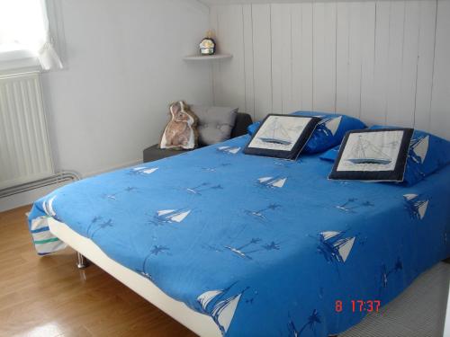 - un lit avec une couette bleue et des oiseaux dans l'établissement Roz Ar vilin, à Moëlan-sur-Mer