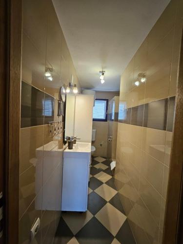 a bathroom with a sink and a mirror at Sunny Pool Apartments in Maslenica