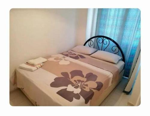a bedroom with a bed with a flower pattern on it at Seferihisar İz Tur sitesinde özel plajlı villa in Seferihisar