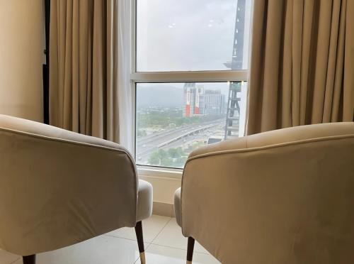 2 sillas frente a una ventana con vistas en Gold Crest Luxury Premium Serviced Apartment DHA - Phase 4 Lahore LMY, en Lahore