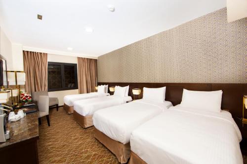 a hotel room with four beds in a room at Dallah Taibah Hotel in Al Madinah