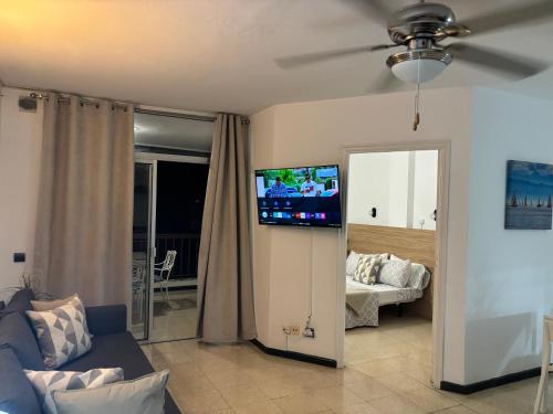 un salon avec une télévision à écran plat au mur dans l'établissement Apartamento con Vistas al Mar, à Los Cristianos