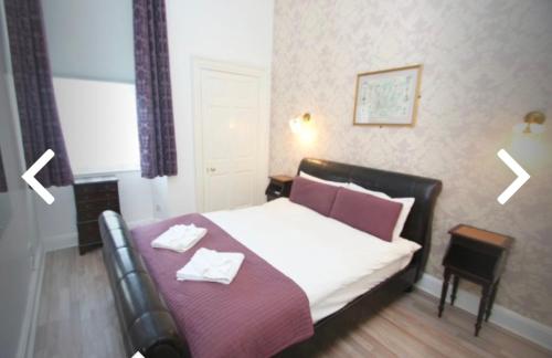 a bedroom with a bed with two towels on it at 52, Charlotte Street Apartments in Glasgow
