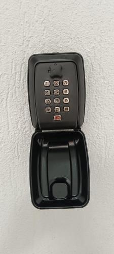 a black cell phone is attached to a wall at Skyline Apart 2 Militari Residence in Roşu