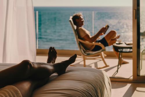 a man laying on the couch in a living room at Iberostar Selection Es Trenc -New Opening- in Colonia Sant Jordi