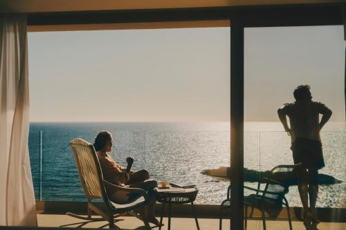 two men sitting in chairs in front of the ocean at Iberostar Selection Es Trenc -New Opening- in Colonia Sant Jordi