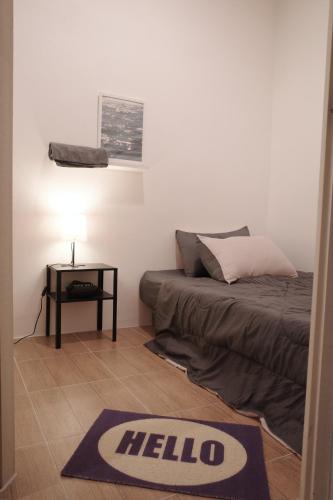 a bedroom with a bed and a table with a hello rug at Round The Clock Hostel in Samphanthawong