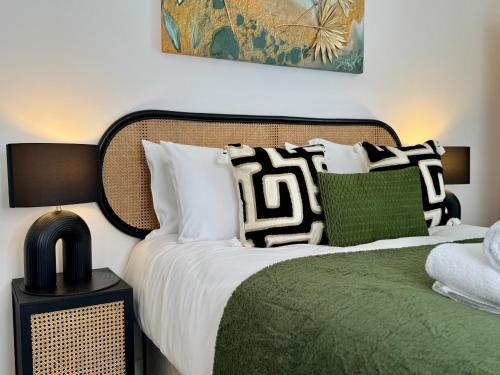 a bedroom with a bed with white and green pillows at Modern Two-Bedroom Flat in Swindon