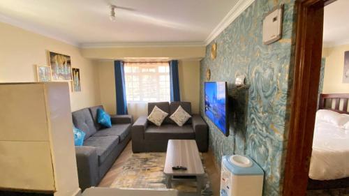 a living room with a couch and a bed at Lowell Stays in Nairobi