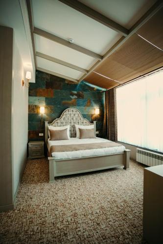a bedroom with a large bed in a room at Hill Chalet Hotel Gabala in Gabala
