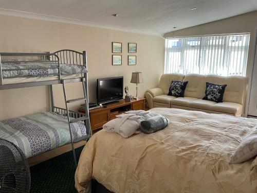 a bedroom with a bunk bed and a couch at Grockle Nook Holiday Apartment in Brixham