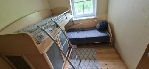 a staircase with a blue chair and a window at Poilsis Juodkrantėje in Juodkrantė