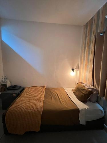 a bed in a small room with a light on at La Locanda in Bangkok