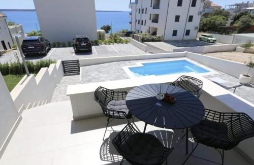 une terrasse avec des chaises et un parasol ainsi qu'une piscine dans l'établissement Dolphin view II with a pool by the beach, à Mandre