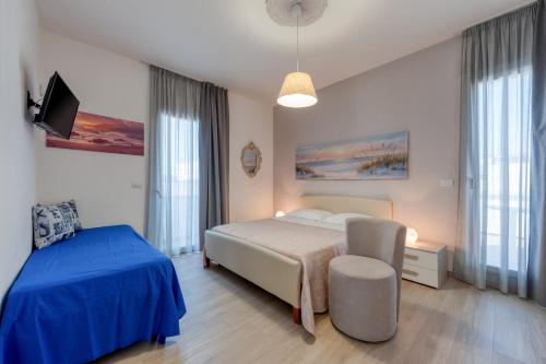 a bedroom with a bed and a chair and a tv at Meravigliosalento in Squinzano