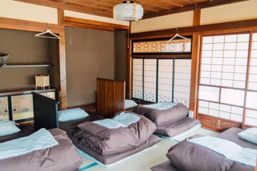 a living room with couches in a room with windows at Koya Backpackers in Karuizawa