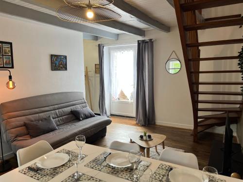 un salon avec un canapé et une table dans l'établissement Maison en pierres à la campagne, à Pleucadeuc