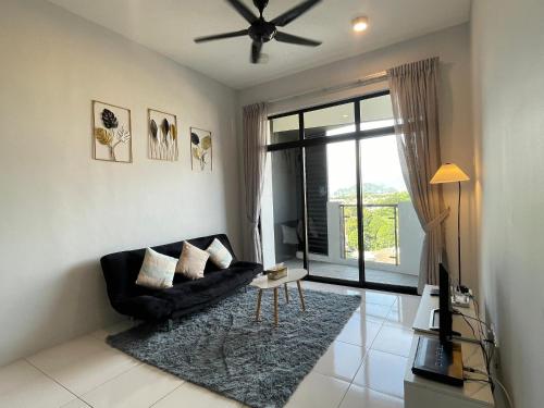 a living room with a black couch and a window at Ipoh Cozy Condo Stadium Greentown 3Br 2bath, 8pax in Ipoh
